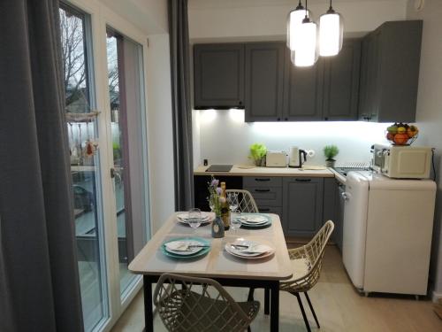 a kitchen with a table and chairs and a white refrigerator at VP Kalamaja Apartment with garage in Tallinn