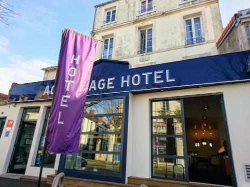una gran señal de hotel frente a un edificio en Accostage Hôtel Plage de la Concurrence en La Rochelle