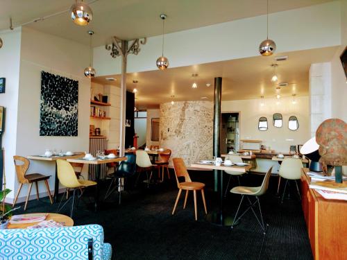 a restaurant with tables and chairs in a room at Accostage Hôtel Plage de la Concurrence in La Rochelle