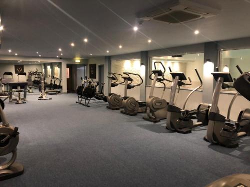 a gym with a bunch of treadmills and exercise bikes at The Beeches Hotel & Leisure Club in Nottingham