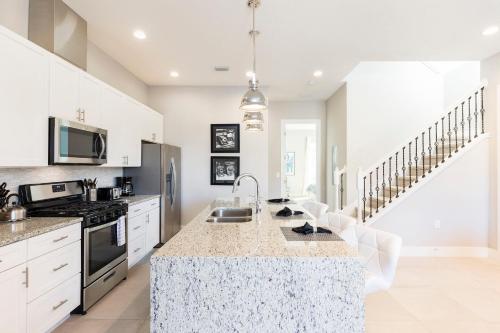 a kitchen with white cabinets and a counter top at 5min Disney Wonderful Villa, BBQ, SMV102 in Orlando