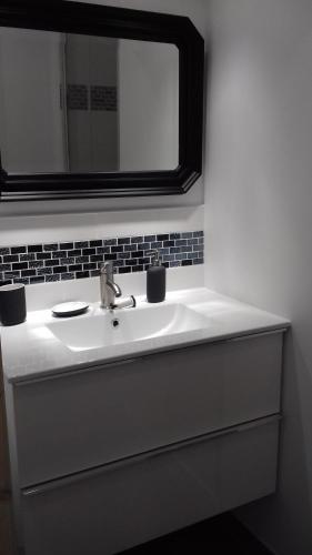 La salle de bains est pourvue d'un lavabo blanc et d'un miroir au-dessus. dans l'établissement LES TILLEULS, à Riez