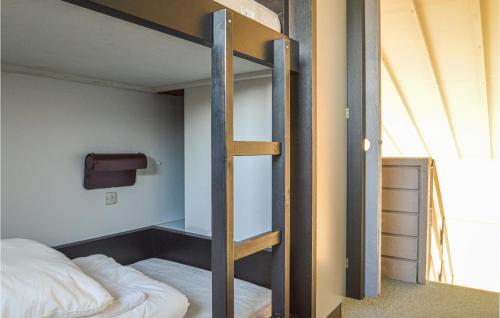 Feriehotel Tranum Klit في Brovst: غرفة نوم مع سرير بطابقين وسلم إلى سرير بطابقين