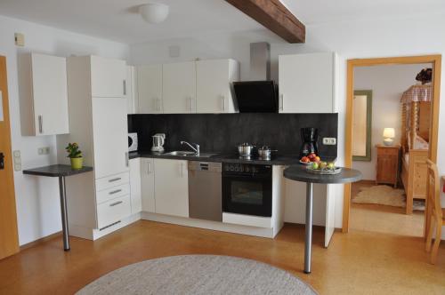 a kitchen with white cabinets and a stove top oven at Ferienwohnung Gäste Oase in Bad Windsheim