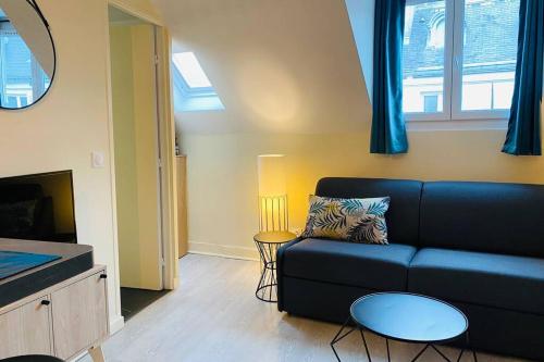 un salon avec un canapé bleu et une télévision dans l'établissement StTUDIO Champs Elysées, à Paris