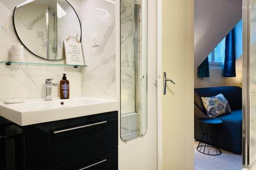 une salle de bain avec un lavabo et un miroir dans l'établissement StTUDIO Champs Elysées, à Paris