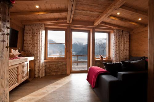 a living room with a couch and a large window at Appartements Wallner in Uttendorf