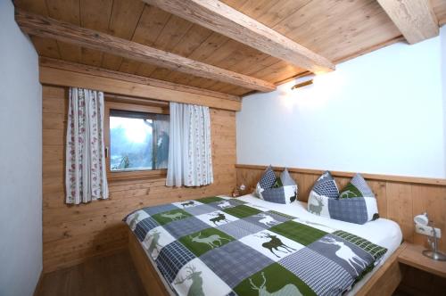 - une chambre avec un lit et un plafond en bois dans l'établissement Appartements Wallner, à Uttendorf