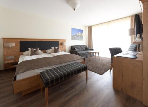 a bedroom with a large bed and a living room at Fetzers Landhotel in Ingelheim am Rhein