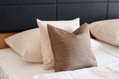 a pile of pillows sitting on a bed at Fetzers Landhotel in Ingelheim am Rhein