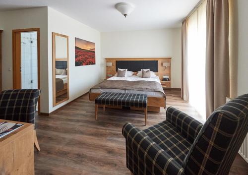 a hotel room with a bed and two chairs at Fetzers Landhotel in Ingelheim am Rhein