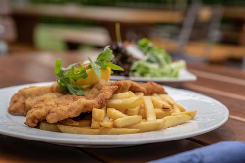 a plate of chicken and french fries on a table at Landgasthof Nagerl in Marzling