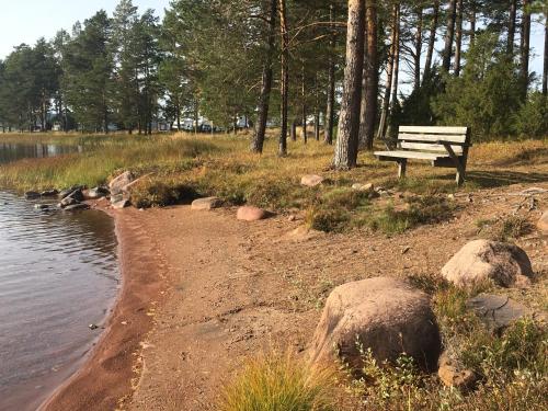 a park bench sitting next to a body of water at Dalastugan in Mora