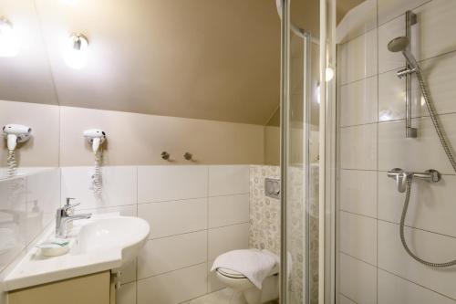 a bathroom with a sink and a shower at American House Puławska in Warsaw
