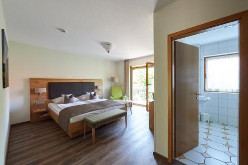 a bedroom with a large bed and a bathroom at Fetzers Landhotel in Ingelheim am Rhein