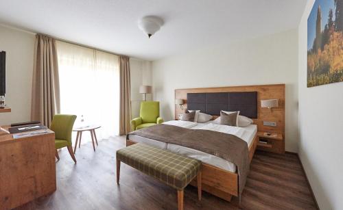 a bedroom with a large bed and a table and chairs at Fetzers Landhotel in Ingelheim am Rhein