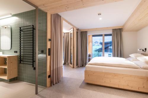 a bedroom with a bed and a bathroom at Mari Pop Hotel in Ried im Zillertal