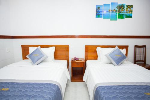 a hotel room with two beds and a table at Thy Hung legacy hotel in Tuy Hoa