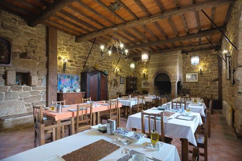 uma sala de jantar com mesas e cadeiras num edifício em Casa dos Ulloa em Esposende