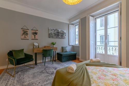 sypialnia z łóżkiem, biurkiem i oknami w obiekcie Sant´Ana Apartment w Lizbonie