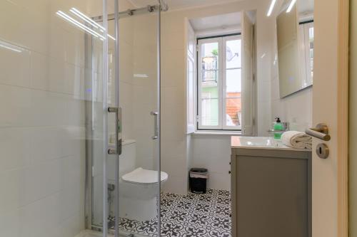 een badkamer met een glazen douche en een wastafel bij Sant´Ana Apartment in Lissabon