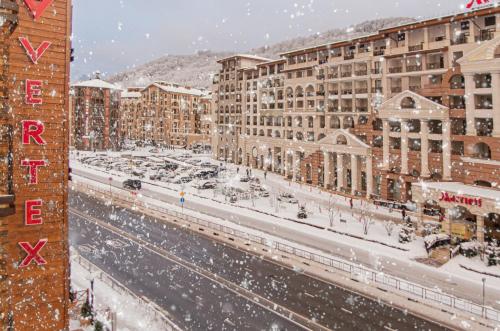 a snow covered city with buildings and a street at VERTEX SPA hotel in Estosadok