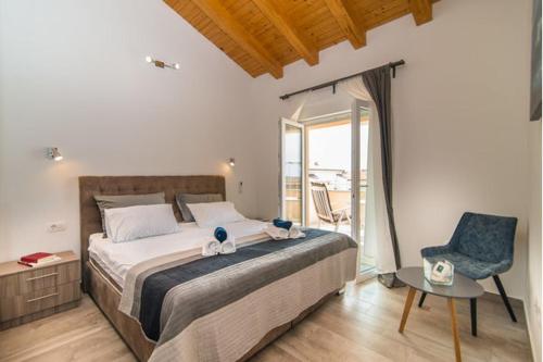 ein Schlafzimmer mit einem großen Bett und einem blauen Stuhl in der Unterkunft Villa Silver Novigrad with private pool in Novigrad Istria