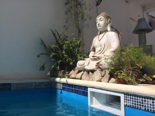 una estatua sentada junto a una piscina al lado de aitatingitatingitatingitatingitatingidad en el hotel Ibiza en Villa Gesell