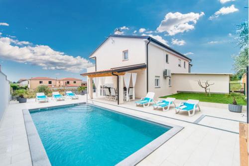 una piscina con sillas y una casa en Villa Silver Novigrad with private pool, en Novigrad Istria
