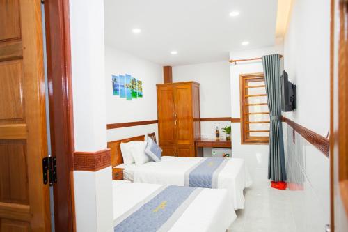 a hotel room with two beds and a television at Thy Hung legacy hotel in Tuy Hoa