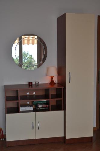 ein Wohnzimmer mit einer Kommode und einem Spiegel in der Unterkunft Poseidon Apartments in Plomin