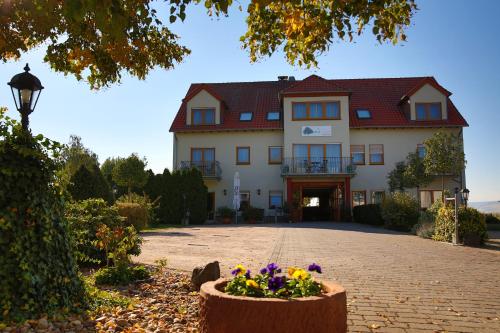 a large white house with flowers in front of it at Fetzers Landhotel in Ingelheim am Rhein