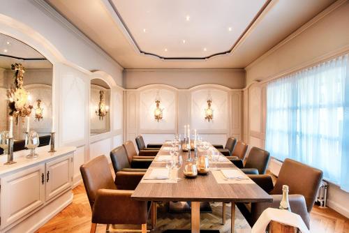 una sala de conferencias con una mesa larga y sillas en Welcome Hotel Schloss Lehen, en Bad Friedrichshall