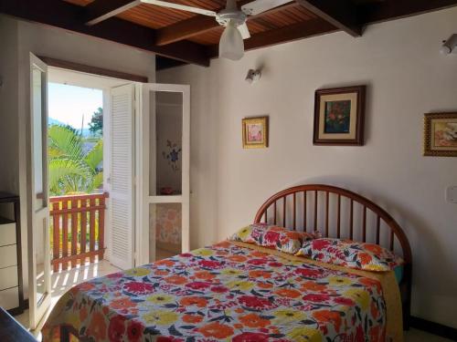 a bedroom with a bed with a colorful comforter at Duplex Top! - Visit and Love Us - Piccola Marina Bracuhy in Angra dos Reis