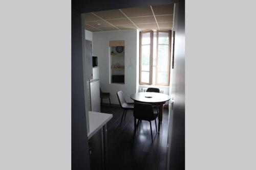 une cuisine et une salle à manger avec une table et des chaises dans l'établissement GITE PARIS - Appartement, à La Clayette