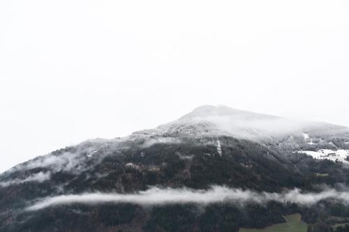 a mountain covered in snow and clouds at Mari Pop Hotel in Ried im Zillertal