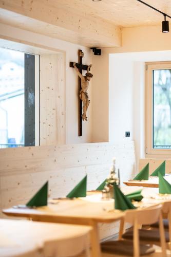 a dining room with wooden tables and a cross on the wall at Mari Pop Hotel in Ried im Zillertal