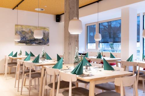 a dining room with tables and chairs with green napkins at Mari Pop Hotel in Ried im Zillertal
