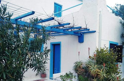 a house with blue beams on the side of it at Oleander's Garden Traditional Cretan Cottage in Ferma