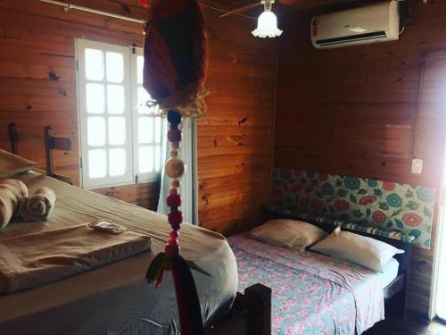 a bedroom with two beds in a log cabin at Pousada Popular Casa de Madeira in Porto De Galinhas