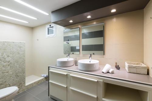 La salle de bains est pourvue de 2 lavabos et de toilettes. dans l'établissement Gouves Beach Boutique Apartment, à Gouves