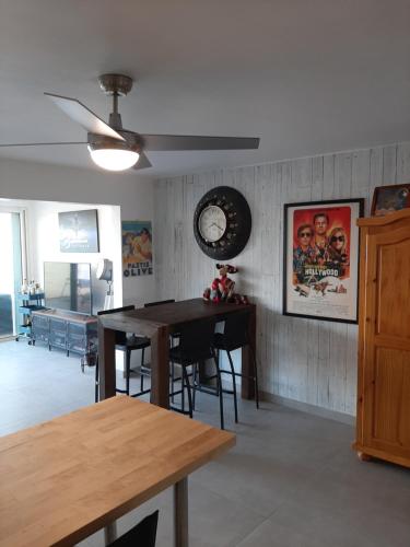 a dining room with a table and a clock on the wall at Tekila Beach, appt-condo au bord de mer a Saint-Martin SXM in Baie Nettle