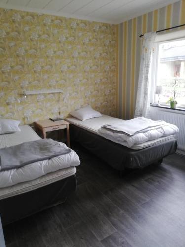 a bedroom with two beds and a window at Gästhuset 32 in Vansbro