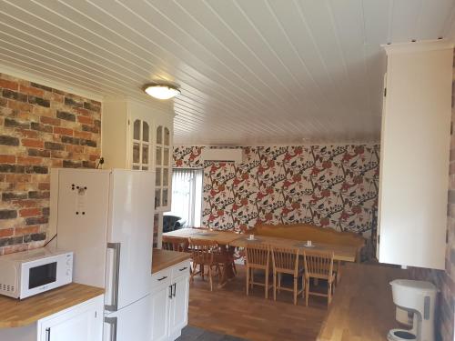 a kitchen with a refrigerator and a table with chairs at Gästhuset 32 in Vansbro