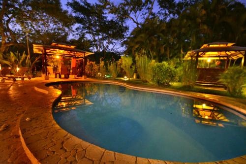 a swimming pool in a yard at night at Lodge Margouillat in Tambor