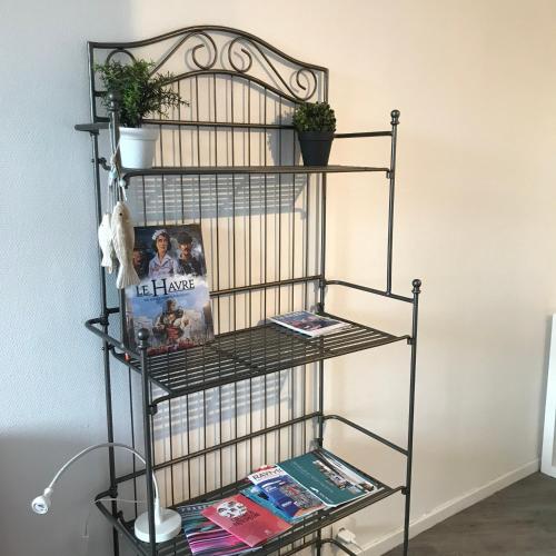 une étagère métallique avec des magazines et des livres dans l'établissement Studio Meublé Vue Mer, au Havre
