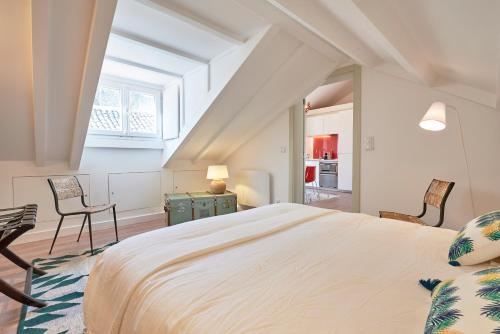 1 Schlafzimmer mit einem großen Bett und 2 Stühlen in der Unterkunft Alfama Chateau - Vue Exceptionelle - Charme - Calme in Lissabon