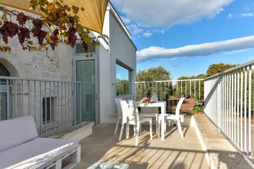 a patio with a table and chairs on a balcony at Trulli Casalina in Cisternino