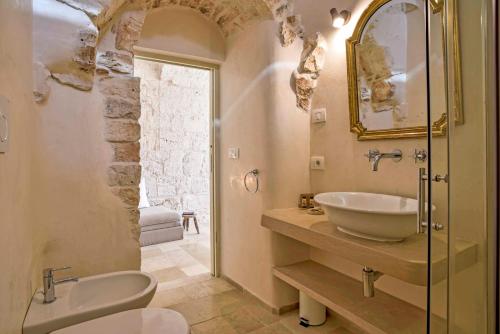 a bathroom with a sink and a toilet and a tub at Trulli Casalina in Cisternino