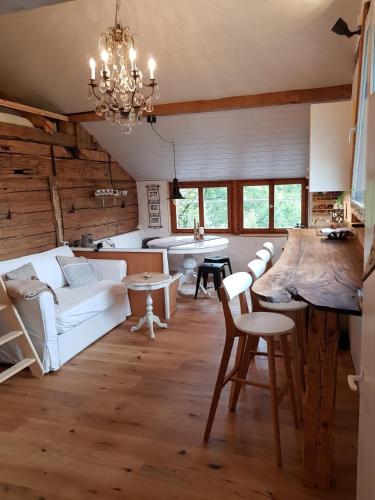 a living room with white furniture and a chandelier at Studio Chic mit Whirlpool in Wildhaus